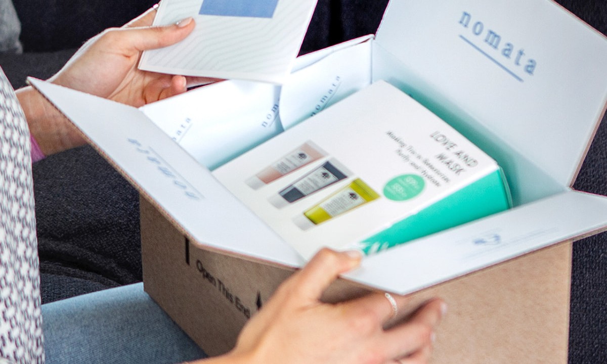 Close-up of an open kraft mailer with printed interior branding and packaged products
